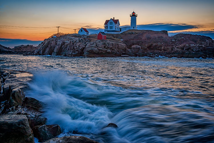 lighthouse sunset with water in the foreground
